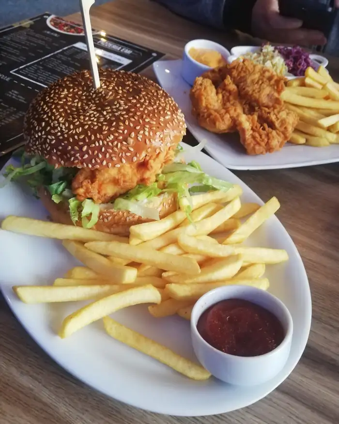 Burger z kurczakiem w chrupiącej panierce z frytkami i sosem