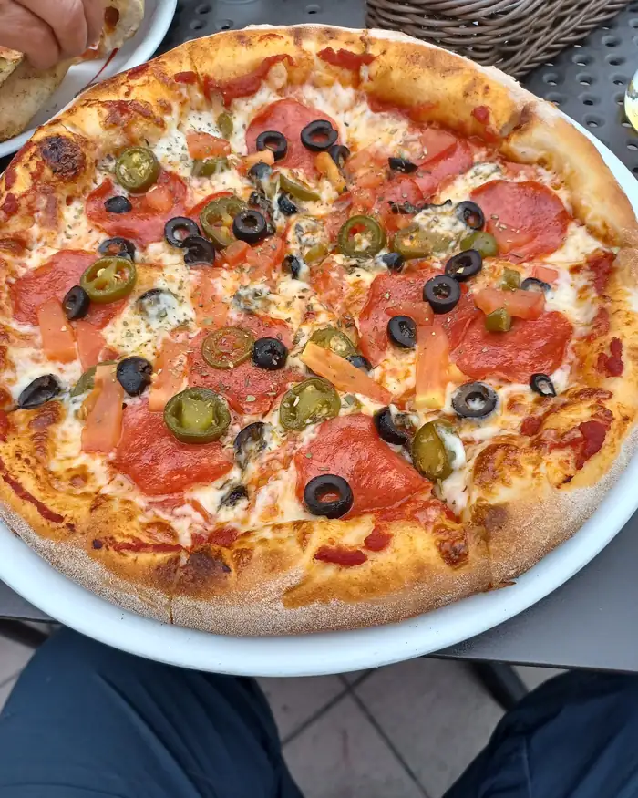 Pizza z salami, czarnymi oliwkami i plastrami jalapeño