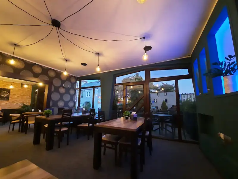 Sala wieczorem pod lampkami zawieszonymi na kablach