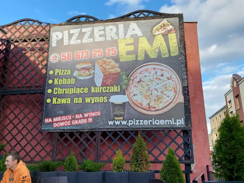 Duża tablica reklamowa Pizzeria EMI z pizzą, kurczakami i napisem na wynos